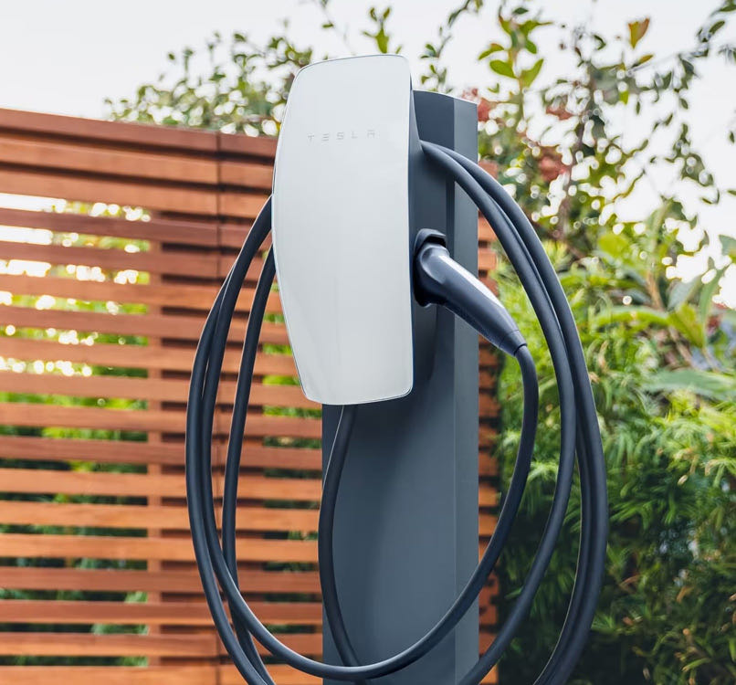 Borne de recharge murale pour véhicule électrique, montée sur un support extérieur avec son câble enroulé
